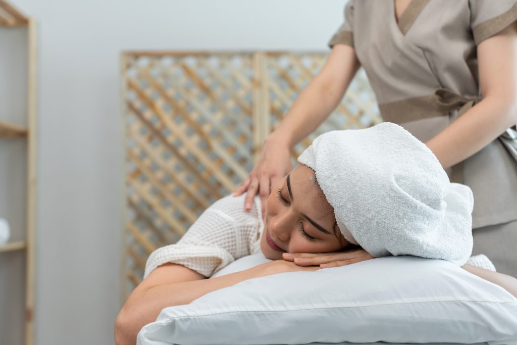 Young woman receiving a massage in a calming spa environment, emphasizing relaxation and wellness for licensed massage therapists in Florida.