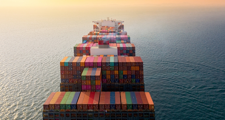 top aerial view of the large volume of TEU containers on ship sailing in the sea carriage the shipment from loading port to destination, heading to the destination of success light