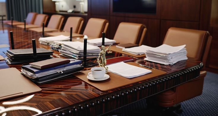Interior of spacious conference room with modern furniture and statue of goddess of justice on table