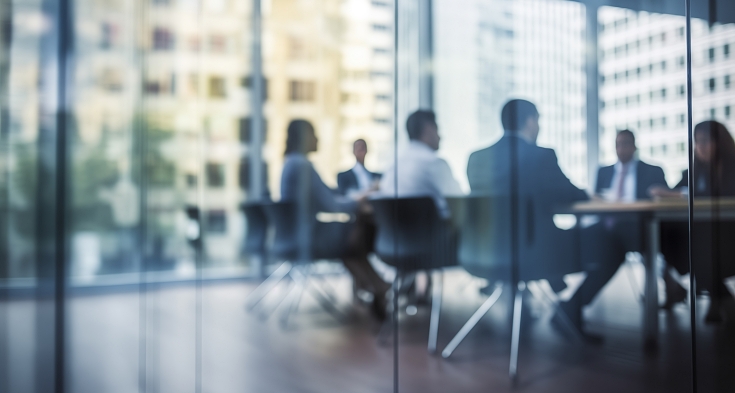 Defocused board meeting background behind glass wall