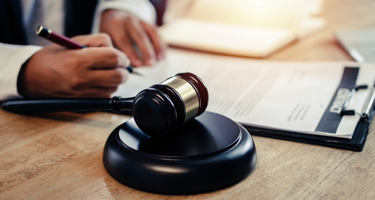 justice lawyer in black suit working about legal legislation with documents on workplace and wooden judge gavel on desk in courtroom office, business adviser, justice law and legal service concept