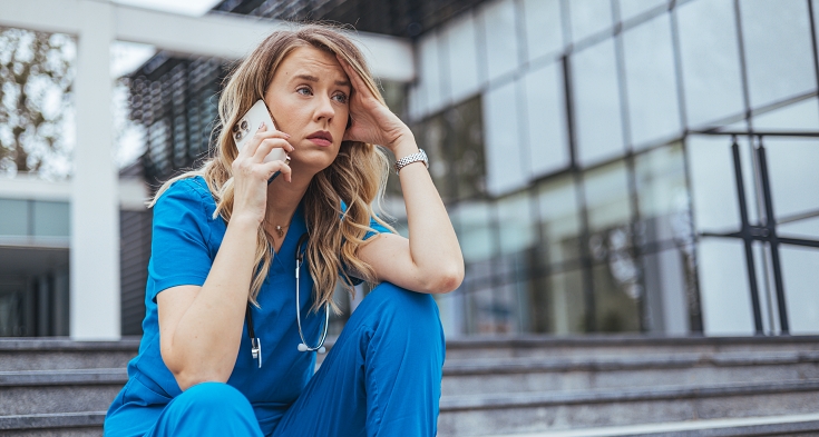 Shot of a young medical practitioner looking stressed out in a hospital.  Exhausted sad doctor feels burnout stress. Worried nurse sitting on floor.